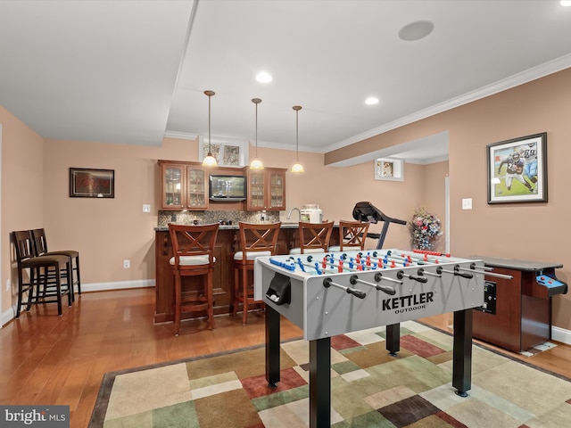 6720 Walter Scott Way, Columbia, MD 21044 - playroom featuring wood finished floors, bar with sink, ornamental molding, and recessed lighting