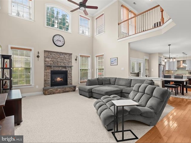 6720 Walter Scott Way, Columbia, MD 21044 - living room with a ceiling fan, healthy amount of natural light, a high ceiling, a fireplace, and light wood-style floors