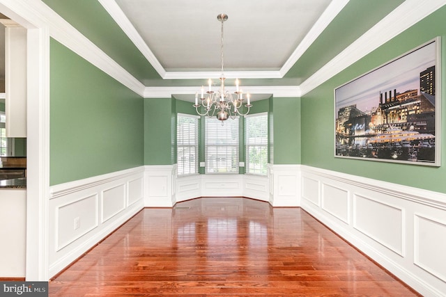 10535 Windlass Run Rd, Baltimore, MD 21220 - unfurnished dining area featuring a tray ceiling, wood finished floors, a chandelier, wainscoting, and a decorative wall