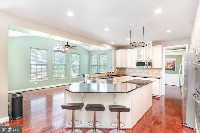 10535 Windlass Run Rd, Baltimore, MD 21220 - kitchen featuring stainless steel appliances, dark wood finished floors, a peninsula, a ceiling fan, and decorative backsplash