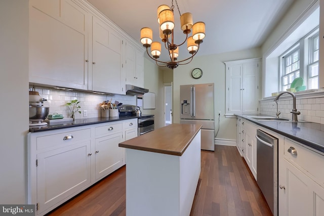 152 Main St, New Providence, PA 17560 - kitchen with appliances with stainless steel finishes, dark countertops, decorative backsplash, under cabinet range hood, and white cabinets