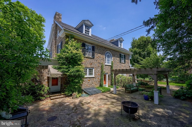 152 Main St, New Providence, PA 17560 - view of front of property with a patio area, stone siding, a pergola, an outdoor fire pit, and a chimney