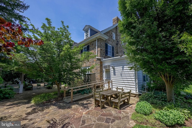 152 Main St, New Providence, PA 17560 - back of property with a patio, stone siding, outdoor dining space, and a chimney