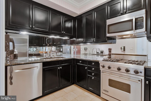 1155 23rd St NW Unit 5L, Washington, DC 20037 - kitchen featuring dark cabinetry, stainless steel appliances, light tile patterned flooring, and stone countertops