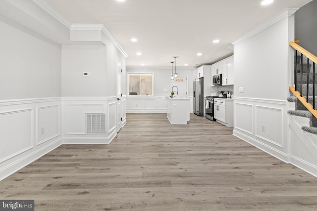 233 S Clinton St, Baltimore, MD 21224 - kitchen with stainless steel appliances, recessed lighting, a center island with sink, crown molding, and a decorative wall
