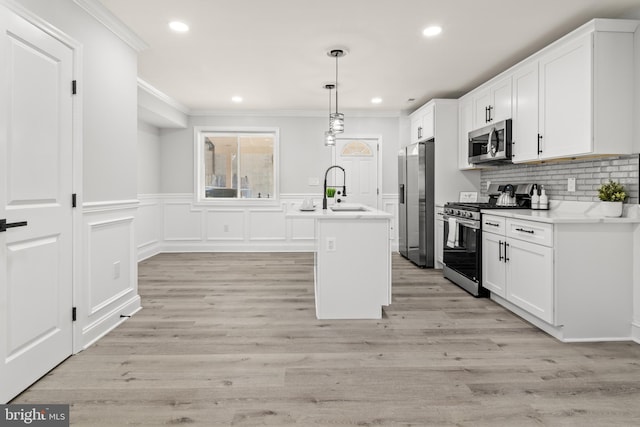 233 S Clinton St, Baltimore, MD 21224 - kitchen featuring stainless steel appliances, crown molding, white cabinets, light countertops, and a kitchen island with sink