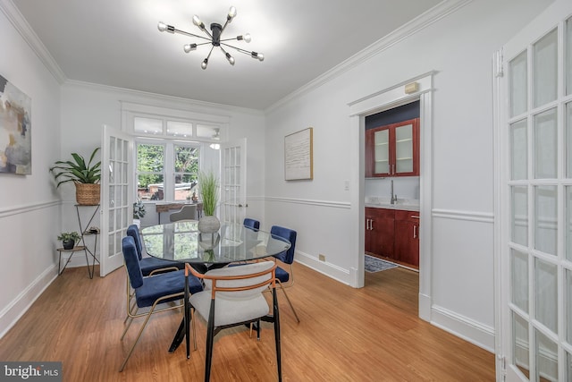 1217 Holbrook St NE, Washington, DC 20002 - dining room featuring french doors, a chandelier, light wood-type flooring, and crown molding