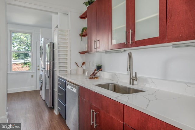 1217 Holbrook St NE, Washington, DC 20002 - kitchen featuring stainless steel dishwasher, estacked washer and dryer, open shelves, light stone countertops, and wood finished floors