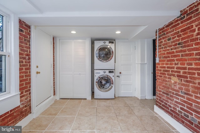 1217 Holbrook St NE, Washington, DC 20002 - washroom featuring stacked washer / dryer, brick wall, and light tile patterned floors