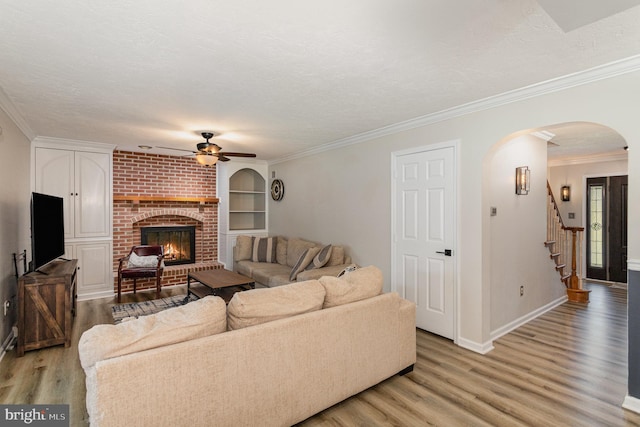 421 Dart Dr, Hanover, PA 17331 - living area featuring a ceiling fan, light wood finished floors, arched walkways, a fireplace, and built in features