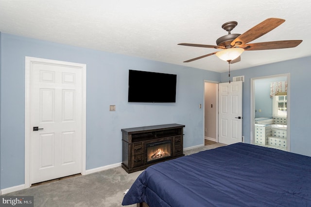 421 Dart Dr, Hanover, PA 17331 - carpeted bedroom featuring a ceiling fan, connected bathroom, and a glass covered fireplace
