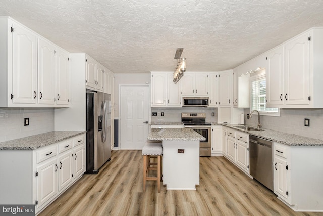 421 Dart Dr, Hanover, PA 17331 - kitchen featuring appliances with stainless steel finishes, white cabinets, light wood-type flooring, and a textured ceiling