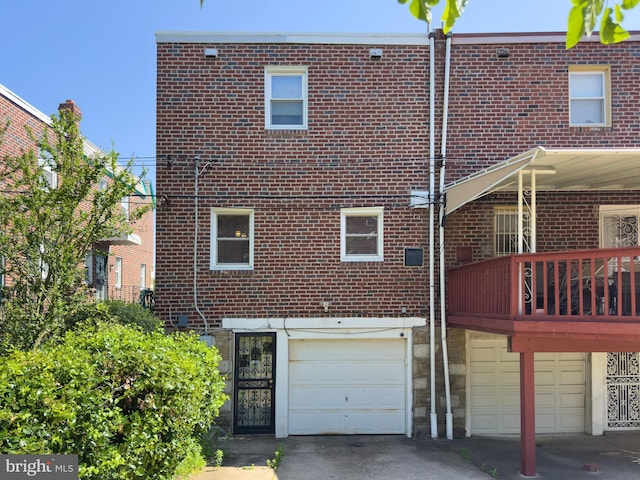 8016 Hollis St, Philadelphia, PA 19150 - rear view of house featuring an attached garage, brick siding, and driveway