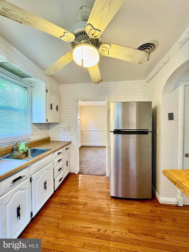 3913 Loch Raven Blvd, Baltimore, MD 21218 - kitchen featuring freestanding refrigerator, ceiling fan, white cabinets, arched walkways, and light wood-style flooring