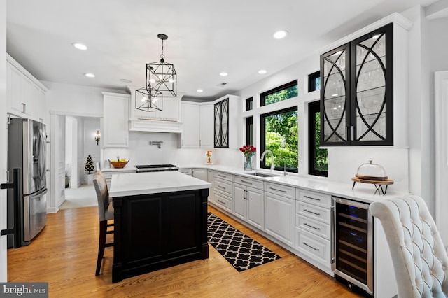 75 Bittersweet Dr, Doylestown, PA 18901 - kitchen with wine cooler, stainless steel refrigerator with ice dispenser, light countertops, a kitchen island, and white cabinetry