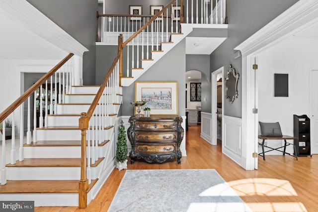 75 Bittersweet Dr, Doylestown, PA 18901 - stairway featuring arched walkways, a high ceiling, wood finished floors, and a wainscoted wall
