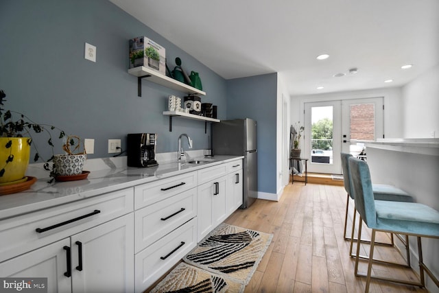 1427 K St SE, Washington, DC 20003 - kitchen with freestanding refrigerator, open shelves, light stone countertops, white cabinetry, and french doors