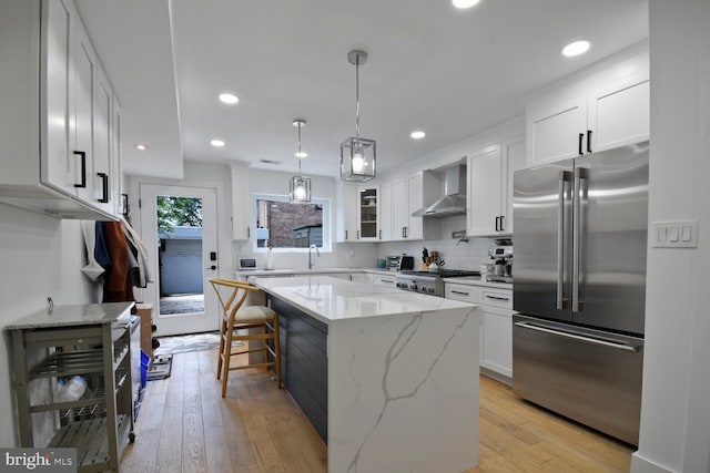 1427 K St SE, Washington, DC 20003 - kitchen featuring high quality fridge, wall chimney exhaust hood, white cabinets, light wood-style floors, and recessed lighting