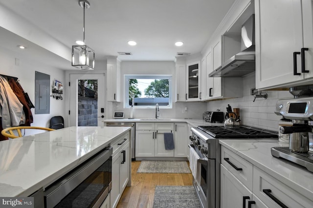 1427 K St SE, Washington, DC 20003 - kitchen with stainless steel appliances, wall chimney range hood, white cabinets, backsplash, and recessed lighting