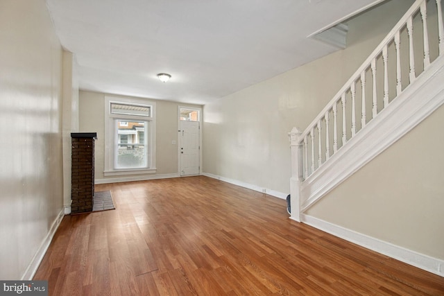 736 Bartlett Ave, Baltimore, MD 21218 - unfurnished living room featuring wood finished floors and stairs