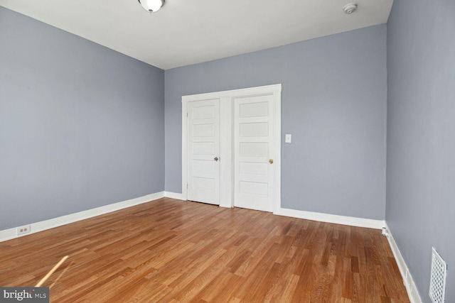 736 Bartlett Ave, Baltimore, MD 21218 - empty room with a smoke detector and wood finished floors