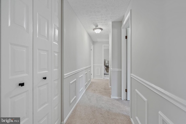 7728 Barnstable Pl, Rockville, MD 20855 - hall with carpet floors, a textured ceiling, and a wainscoted wall