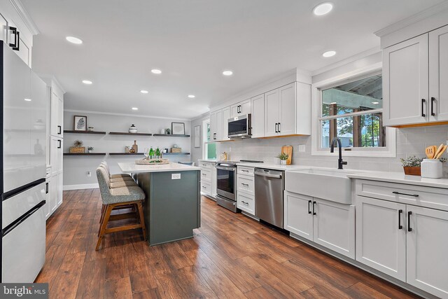 7728 Barnstable Pl, Rockville, MD 20855 - kitchen with appliances with stainless steel finishes, open shelves, tasteful backsplash, a breakfast bar, and recessed lighting
