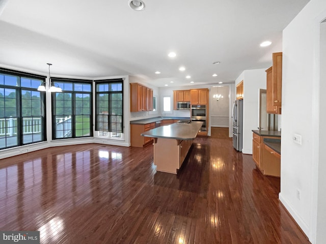 12054 Greatbridge Rd, Woodbridge, VA 22192 - kitchen with stainless steel appliances, a center island, dark countertops, dark wood-style floors, and a breakfast bar area