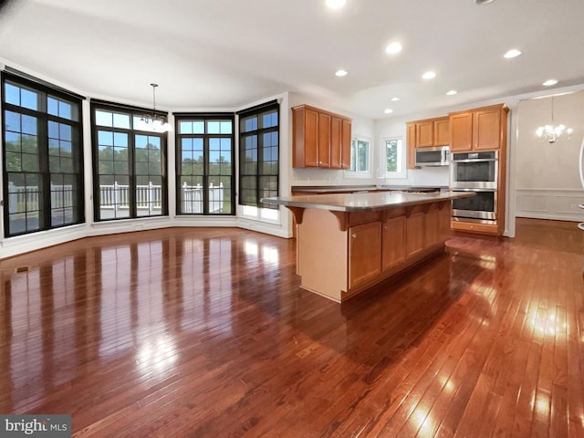 12054 Greatbridge Rd, Woodbridge, VA 22192 - kitchen featuring a chandelier, appliances with stainless steel finishes, dark wood-style floors, a breakfast bar, and recessed lighting