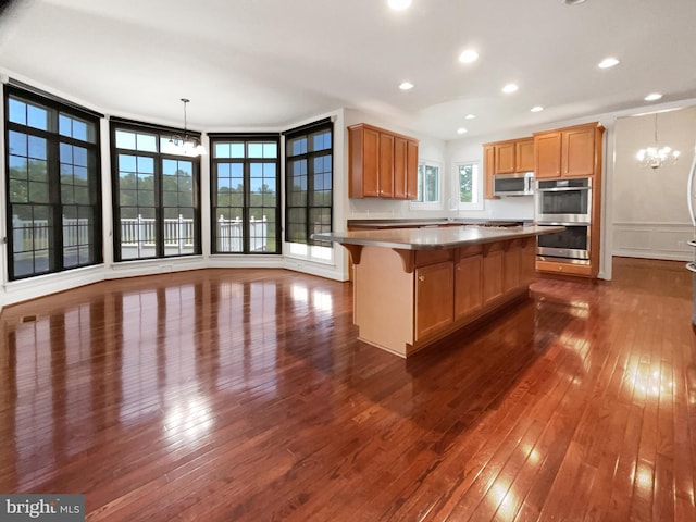 12054 Greatbridge Rd, Woodbridge, VA 22192 - kitchen with a chandelier, appliances with stainless steel finishes, dark wood-style floors, a kitchen breakfast bar, and recessed lighting