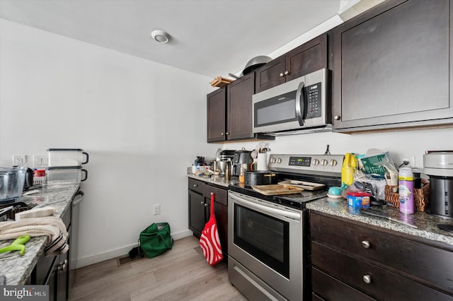 3104 N Broad St, Philadelphia, PA 19132 - kitchen with appliances with stainless steel finishes, light wood-style flooring, dark brown cabinetry, and light stone countertops