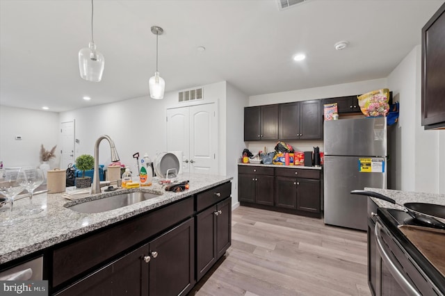 3104 N Broad St, Philadelphia, PA 19132 - kitchen with freestanding refrigerator, range with electric stovetop, dark brown cabinetry, light stone countertops, and light wood-style floors