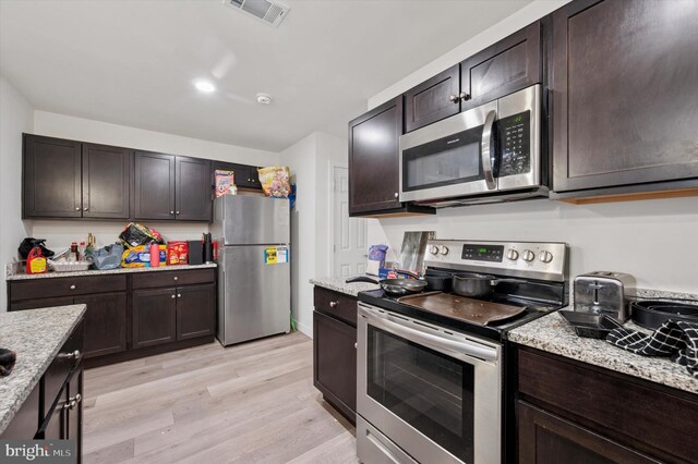 3104 N Broad St, Philadelphia, PA 19132 - kitchen featuring stainless steel appliances, light wood-style floors, dark brown cabinets, and light stone countertops