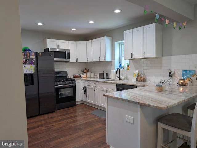700 S Belleview Ave, Cinnaminson, NJ 08077 - kitchen with black appliances, a peninsula, white cabinetry, light stone counters, and recessed lighting