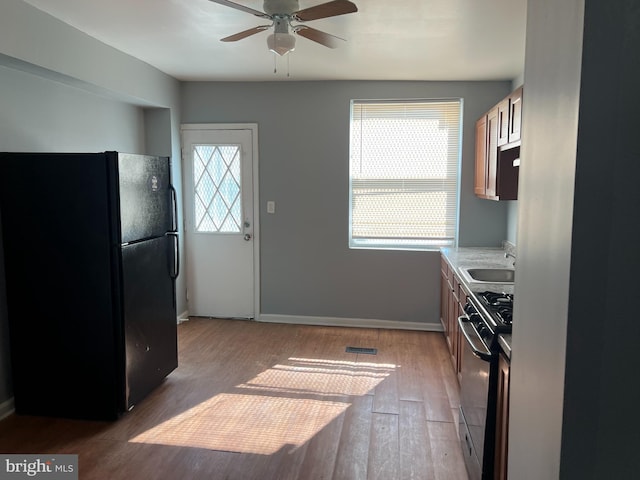 1819 Presstman St, Baltimore, MD 21217 - kitchen featuring freestanding refrigerator, range, ceiling fan, light wood-style flooring, and light countertops