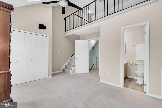 8916 Rosewood Way, Jessup, MD 20794 - unfurnished living room featuring a towering ceiling, ceiling fan, carpet floors, and stairs