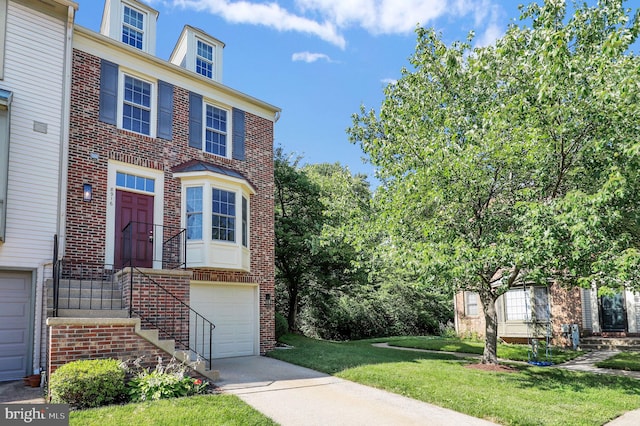 8916 Rosewood Way, Jessup, MD 20794 - townhome / multi-family property featuring brick siding, a front yard, an attached garage, and concrete driveway