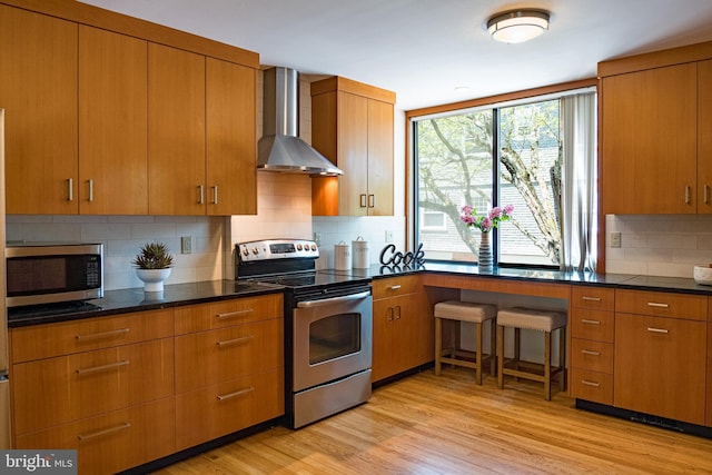 33 Sergeant St, Princeton, NJ 08540 - kitchen featuring stainless steel appliances, wall chimney exhaust hood, backsplash, and light wood finished floors