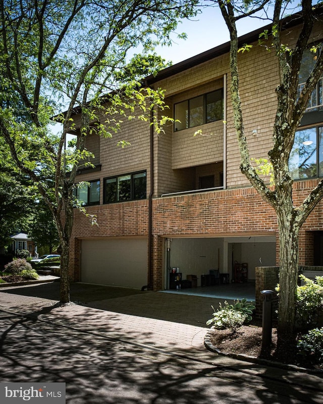 33 Sergeant St, Princeton, NJ 08540 - view of side of home featuring an attached garage, decorative driveway, and brick siding