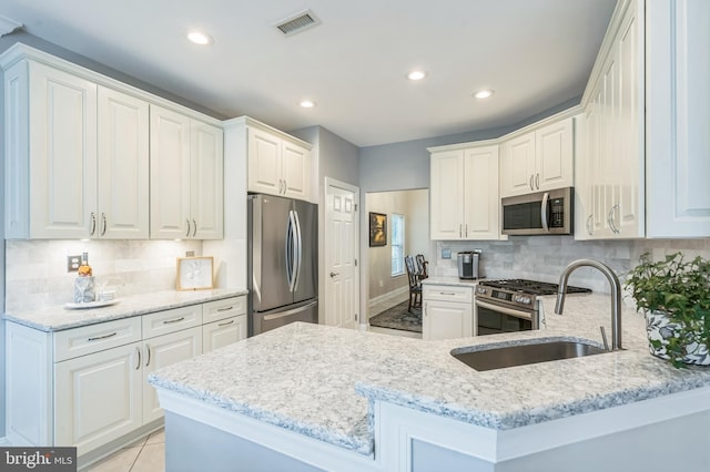 1 Springfield Ave, Berlin, NJ 08009 - kitchen with stainless steel appliances, light stone countertops, decorative backsplash, a peninsula, and recessed lighting
