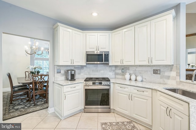1 Springfield Ave, Berlin, NJ 08009 - kitchen with appliances with stainless steel finishes, white cabinets, backsplash, and a chandelier