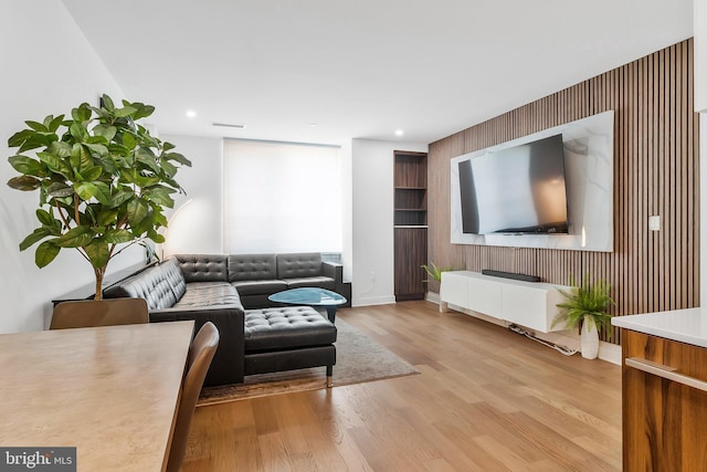 37 L St SE Unit 101, Washington, DC 20003 - living room with radiator, wood finished floors, wood walls, an accent wall, and recessed lighting