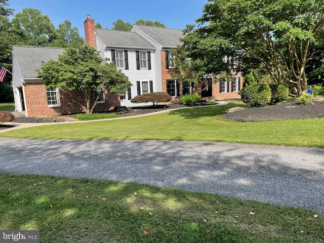 11 Georges Way, Glen Mills, PA 19342 - view of front of property featuring a chimney, brick siding, a front lawn, and roof with shingles