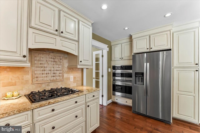 11 Georges Way, Glen Mills, PA 19342 - kitchen featuring appliances with stainless steel finishes, cream cabinets, light stone countertops, dark wood-type flooring, and backsplash