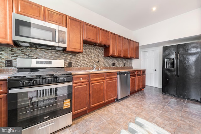 5820 Alter St, Philadelphia, PA 19143 - kitchen featuring stainless steel appliances, tasteful backsplash, light countertops, and brown cabinetry