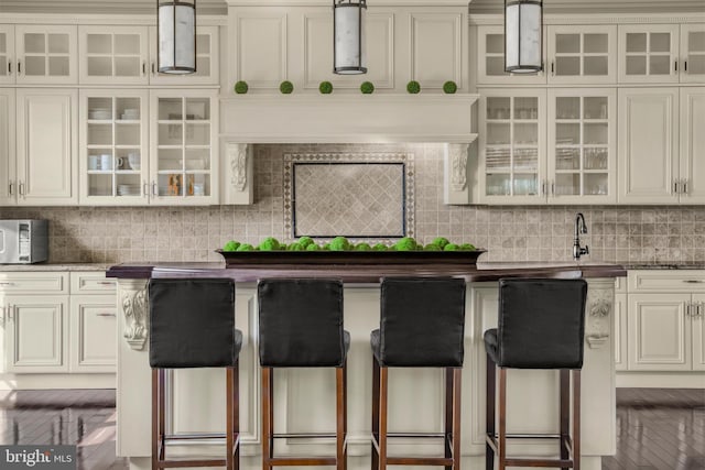 1315 Canal Rd, Princeton, NJ 08540 - kitchen with a breakfast bar area, backsplash, stainless steel microwave, and glass insert cabinets