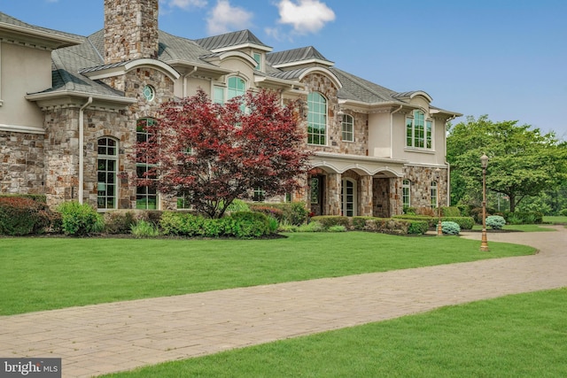 1315 Canal Rd, Princeton, NJ 08540 - french country style house featuring stone siding, stucco siding, a chimney, a front lawn, and a standing seam roof