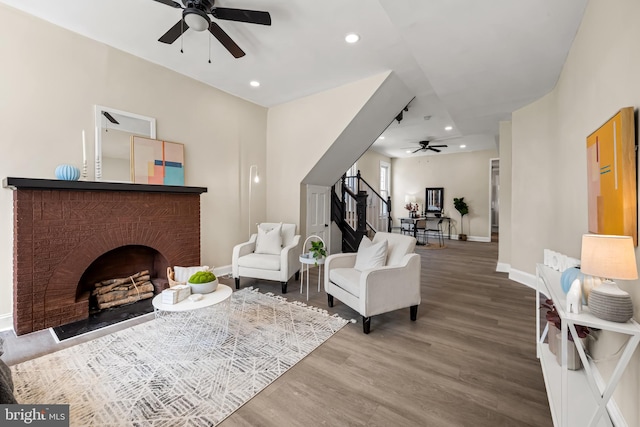 2011 Boone St, Baltimore, MD 21218 - living room with a ceiling fan, wood finished floors, recessed lighting, a brick fireplace, and stairway