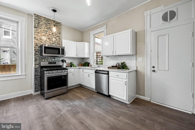 2011 Boone St, Baltimore, MD 21218 - kitchen with appliances with stainless steel finishes, light countertops, tasteful backsplash, and dark wood-type flooring