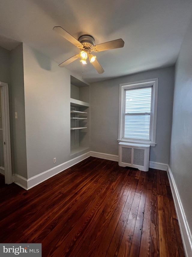 453 Belgrade St, Philadelphia, PA 19125 - spare room featuring radiator heating unit, dark wood-style flooring, built in shelves, and ceiling fan